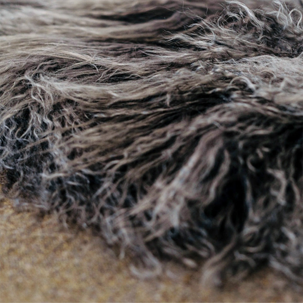 A close up picture of chocolate colored shearling on wool.