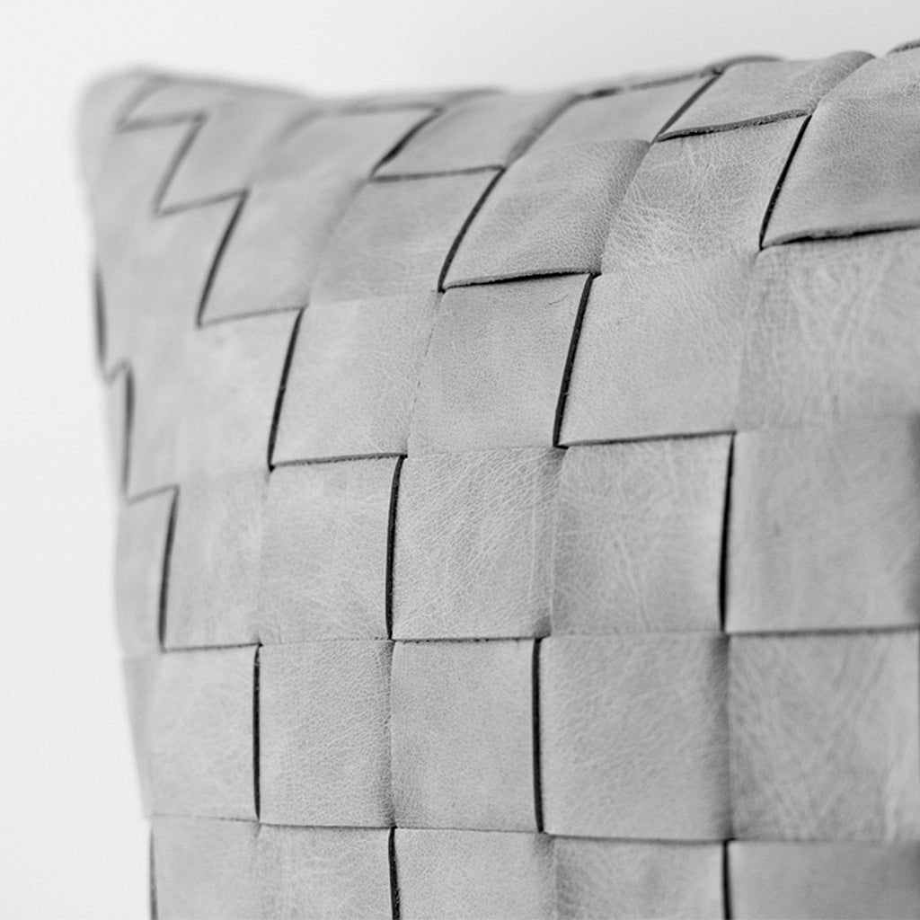 Woven pillow with leather strips black and white photography.