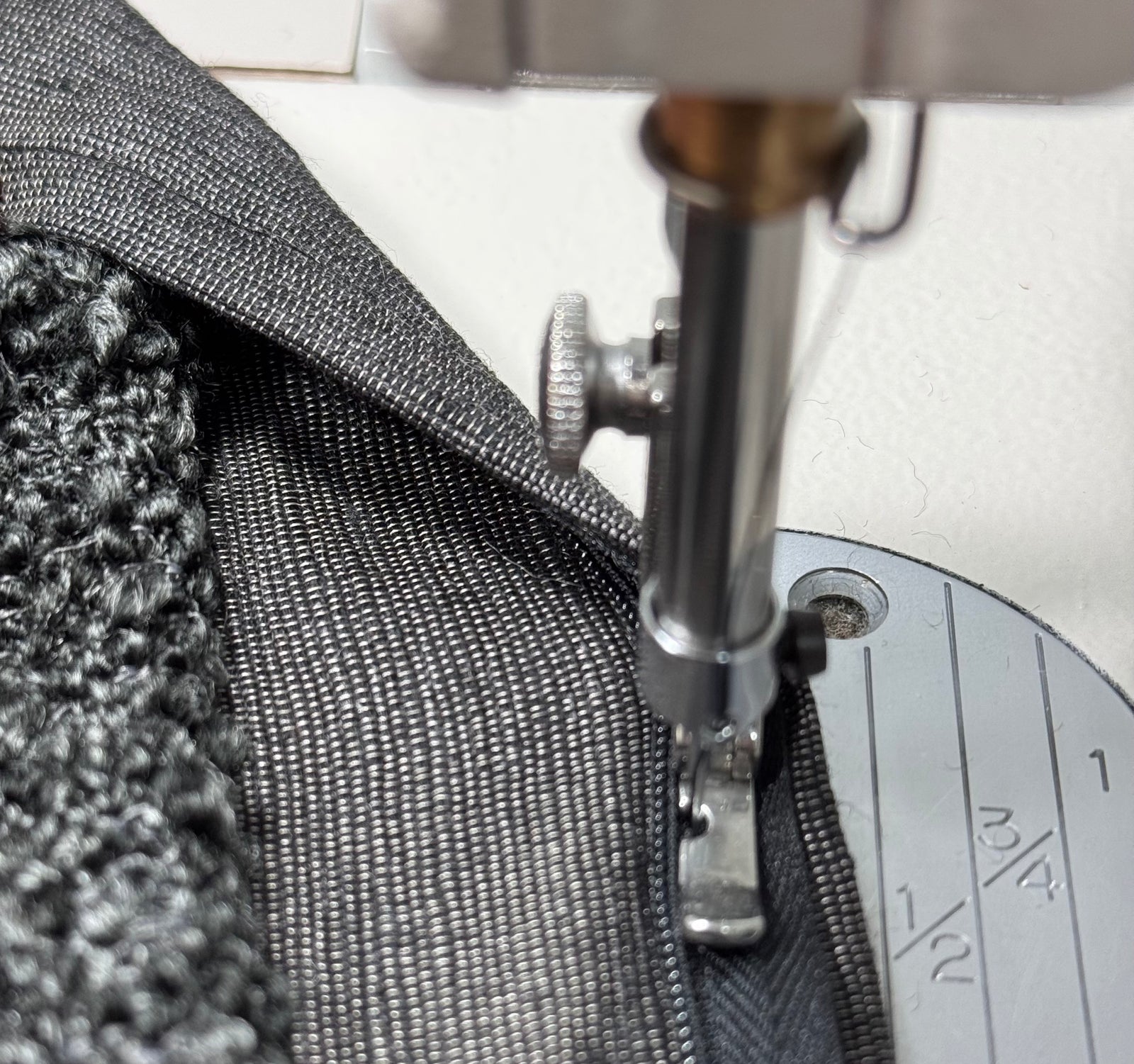 Close-up of a sewing machine needle stitching fabric