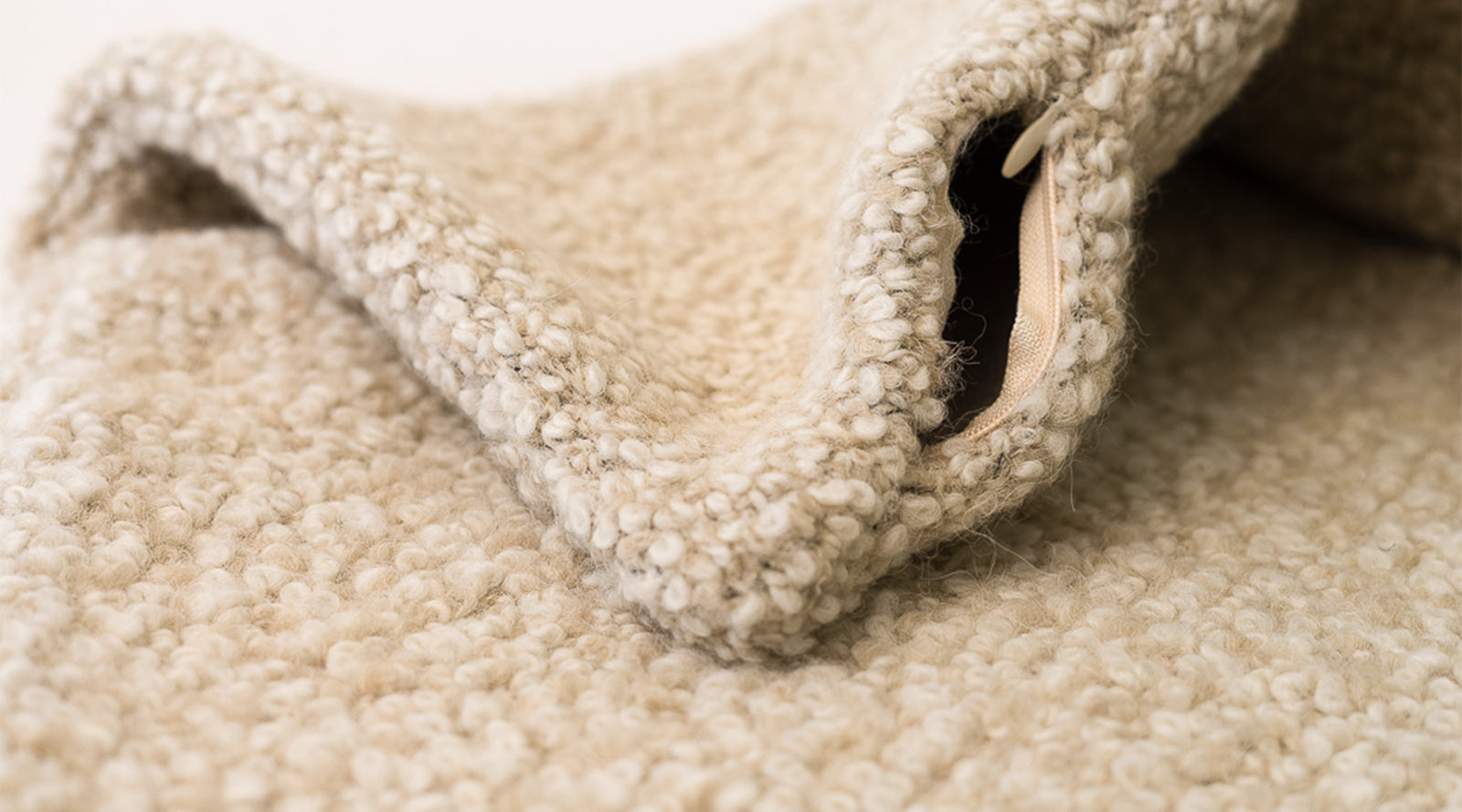 Alpaca boucle pillow cover with exposed zipper detail, natural ivory texture, ADALÉI