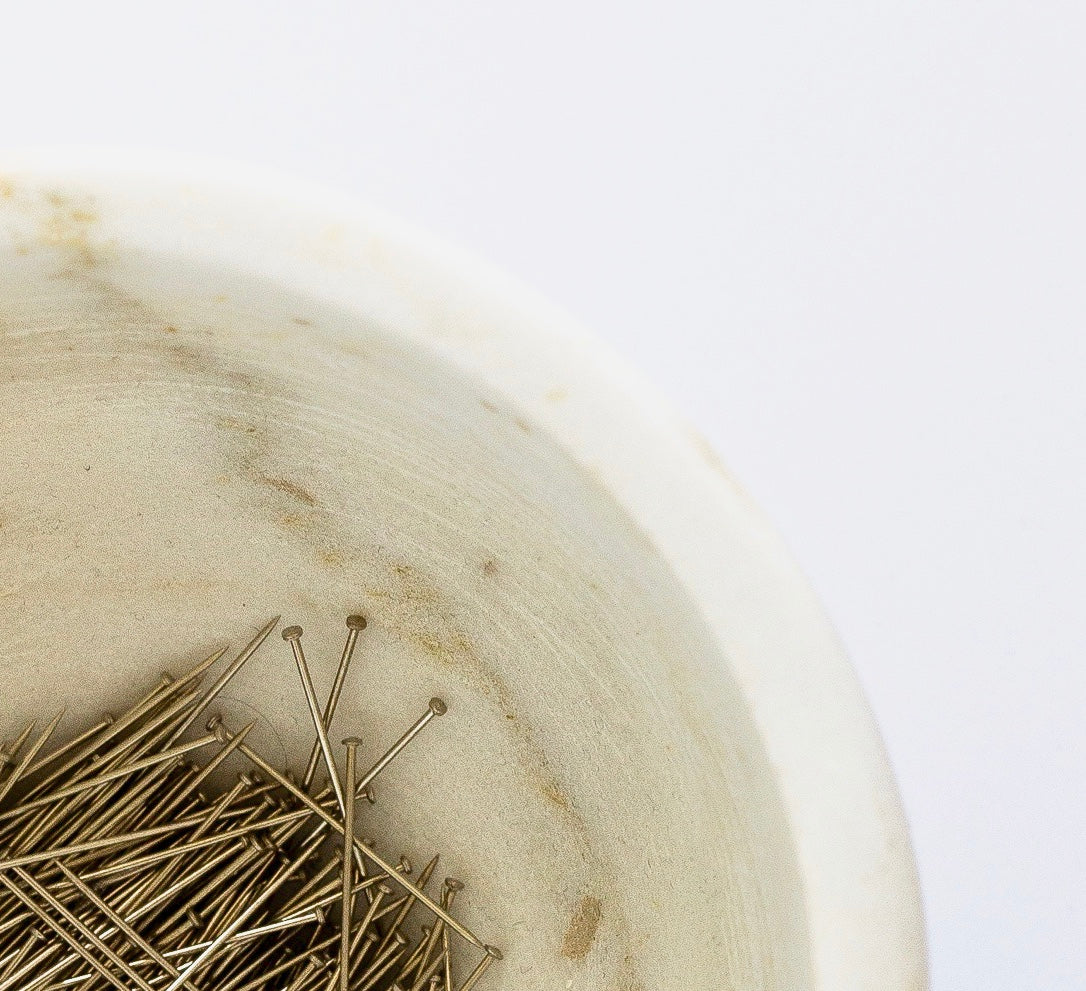 Marble bowl with pins on white background.  Design with Intention NC Trade Application ADALÉI Studio Workroom to NC Trade.  