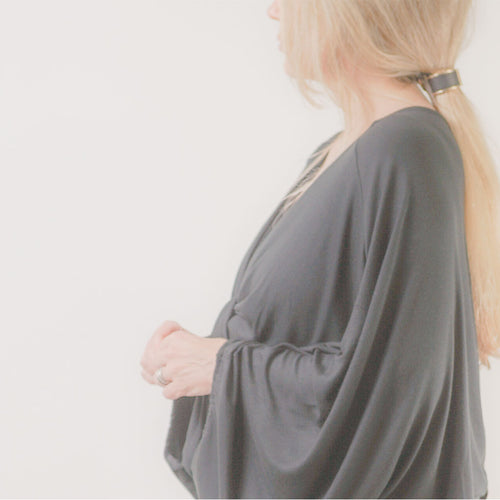 Founder of ADALÉI, standing in profile wearing an original design, Raleigh NC studio


